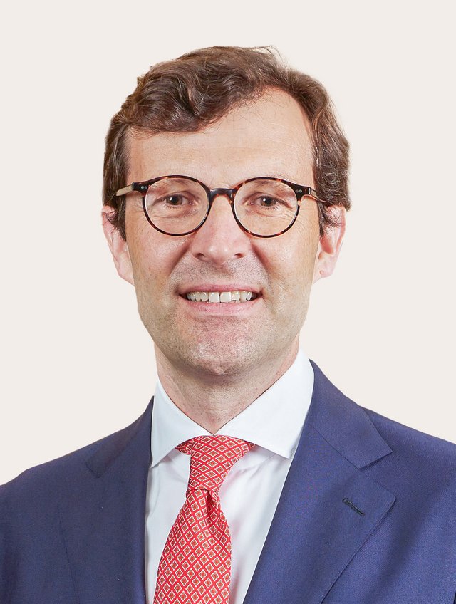 Ein Foto von Christoph Schaltegger vor beigem Hintergrund.