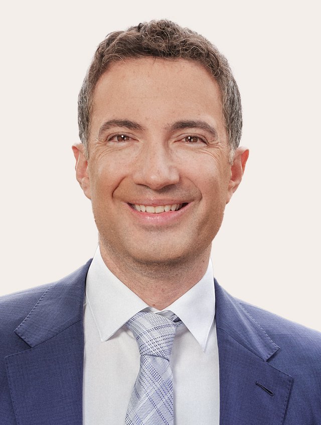 Ein Foto von Andrea Caroni vor beigem Hintergrund.